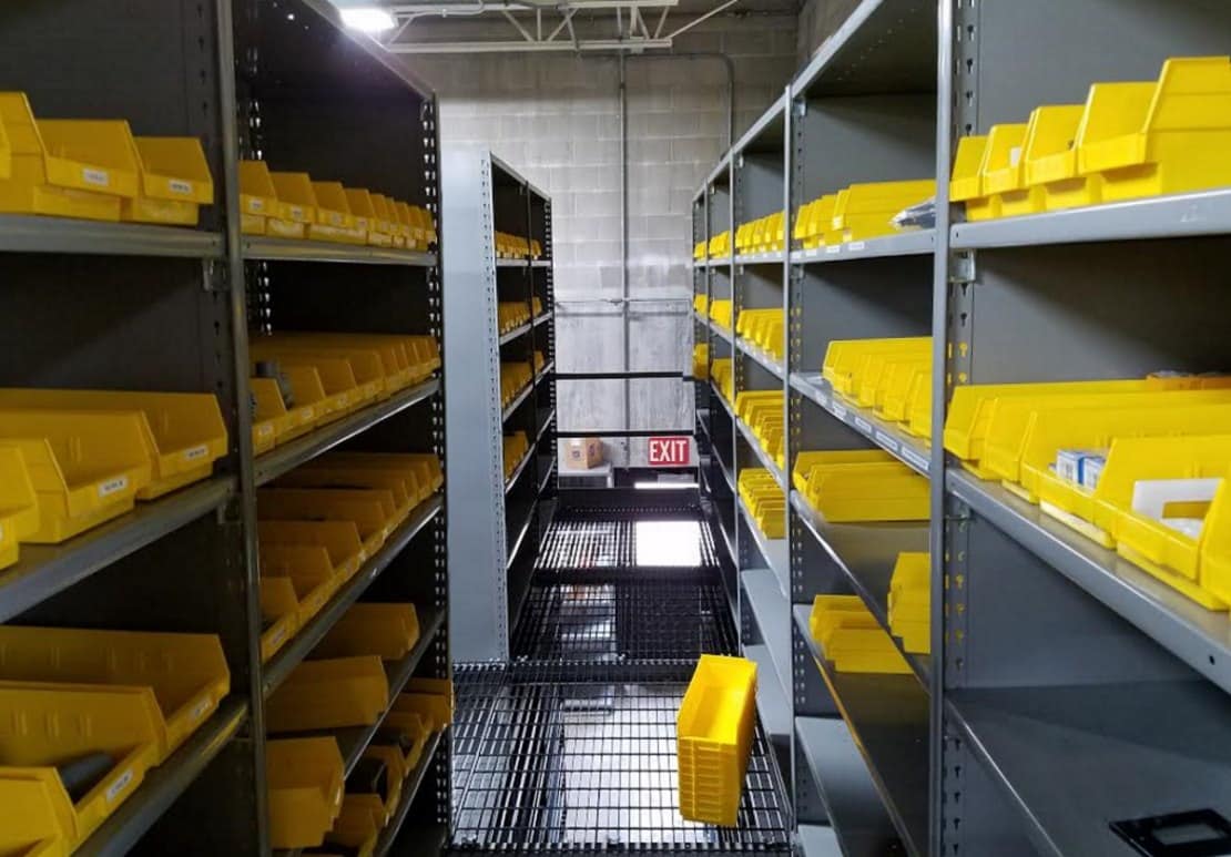 warehouse with two level steel warehouse shelving and plastic yellow parts bins